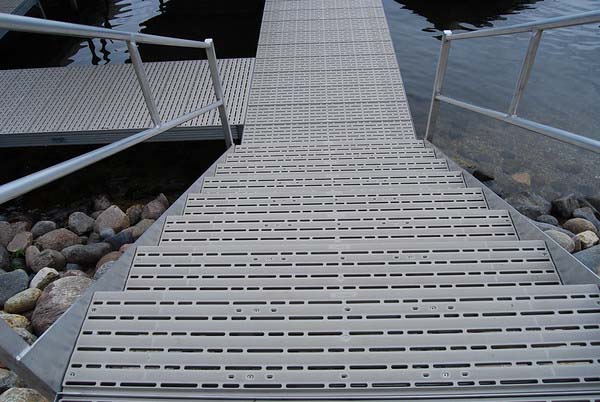 A staircase with metal railing leading down to  dock over the water. 