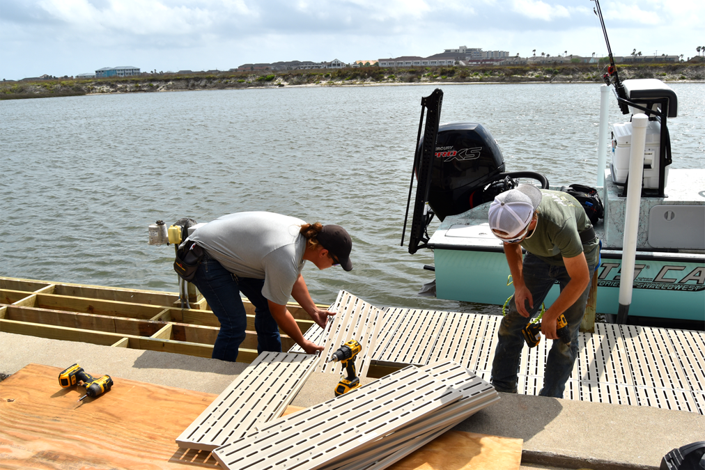 Two men installing Titan Classic boards onto an existing wood framed dock.
