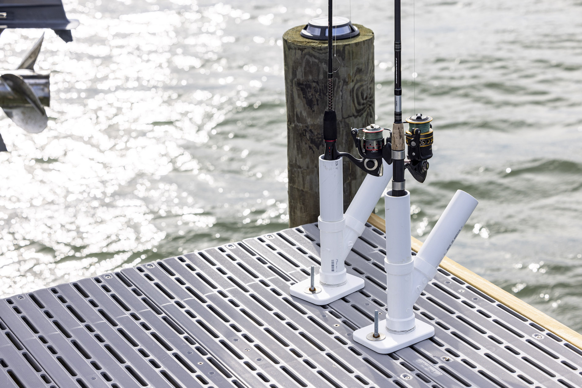 Fishing rod holders mounted onto Titan classic boards applied to a wood deck frame over the ocean.
