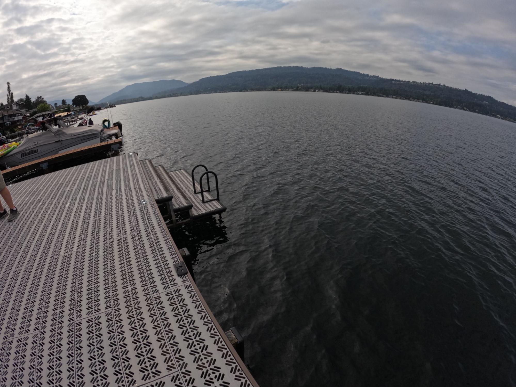 Titan Deck decking is located on a lake. There are three steps leading to a ladder for easy access to the water. 