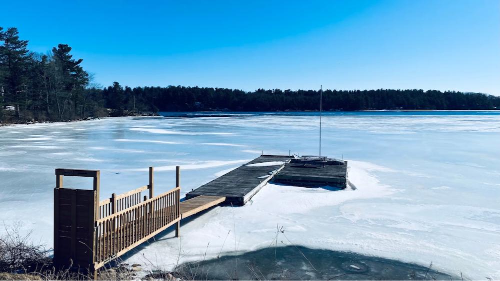 An image of a dock over a frozen lake. 