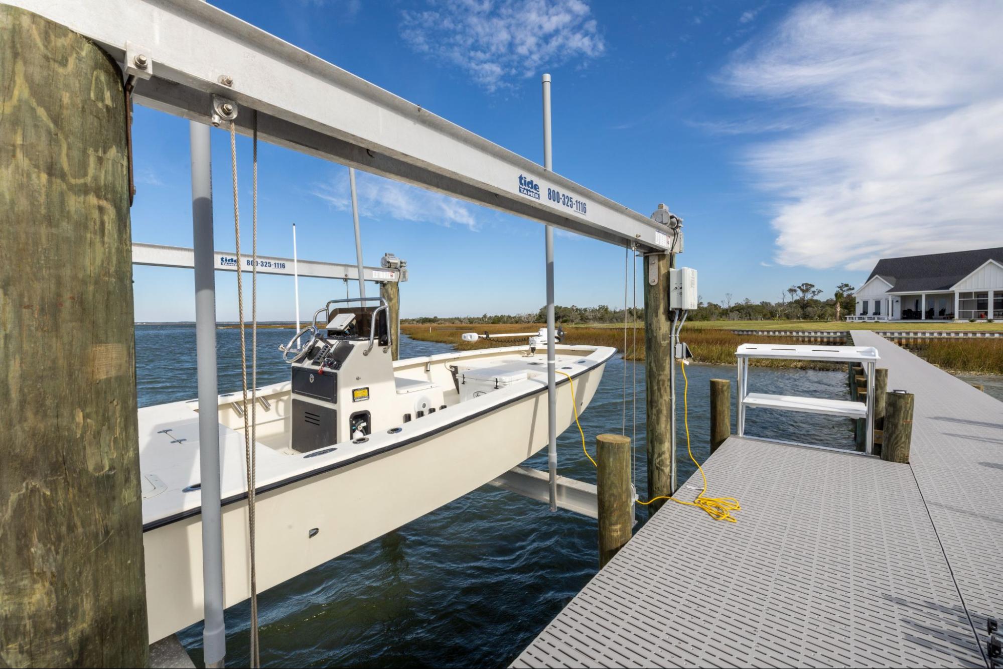 A white boat next to a marine dock on a lake with Titan Deck marine decking.