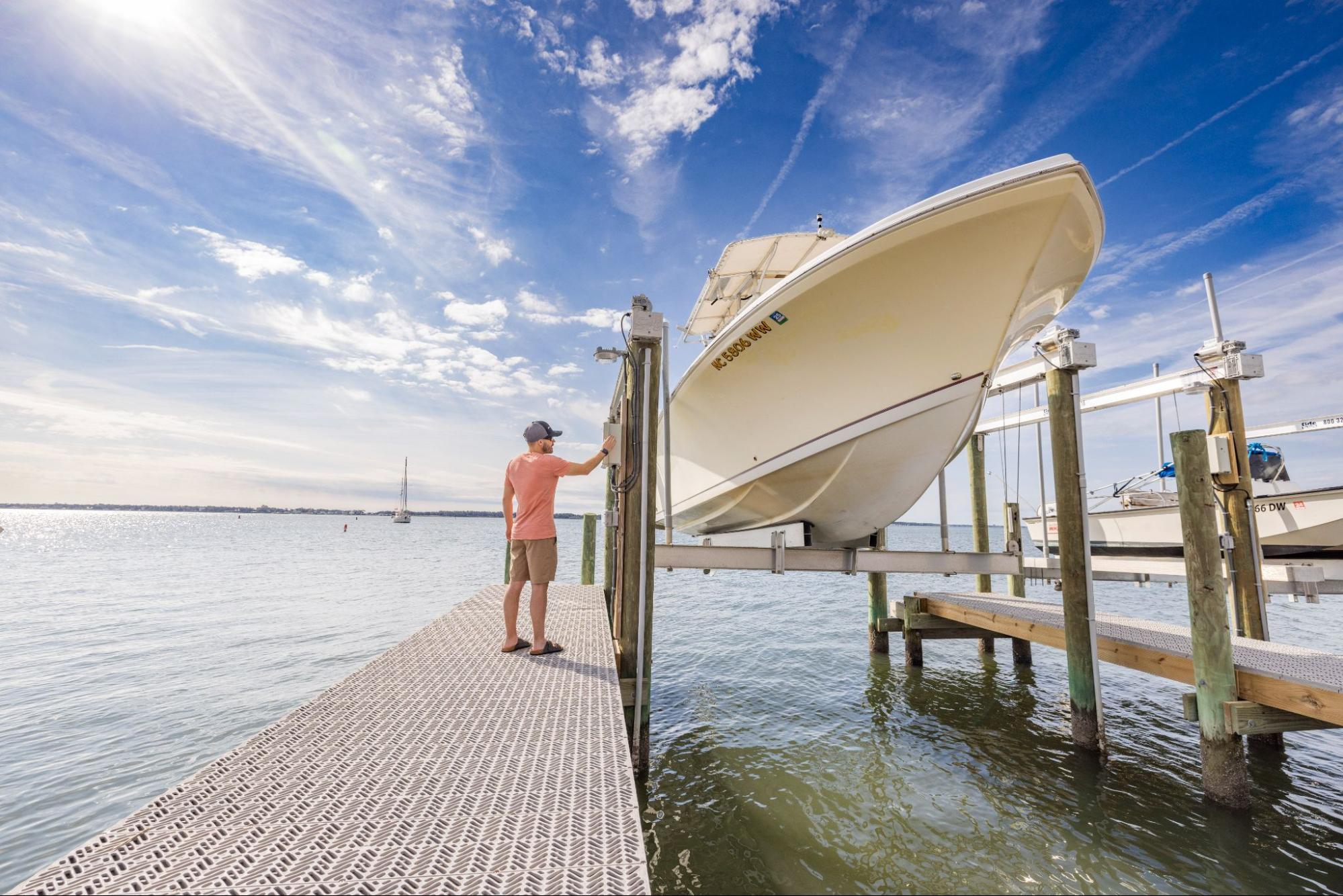 A man standing at a boat lift on a deck made of Titan Deck.