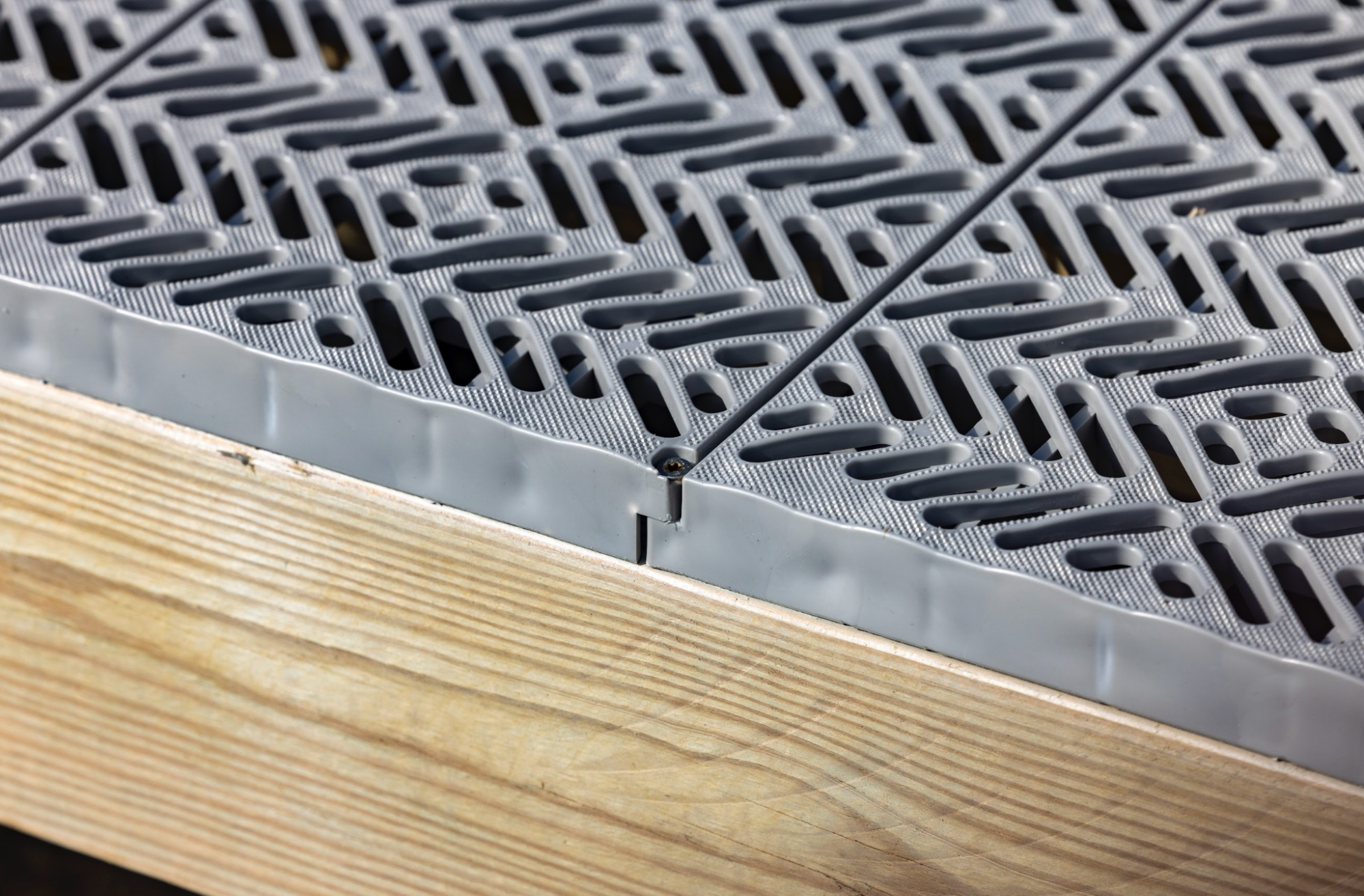 A detailed image of a waterfront deck design, featuring a close-up of a Titan Deck board and its grid profile.