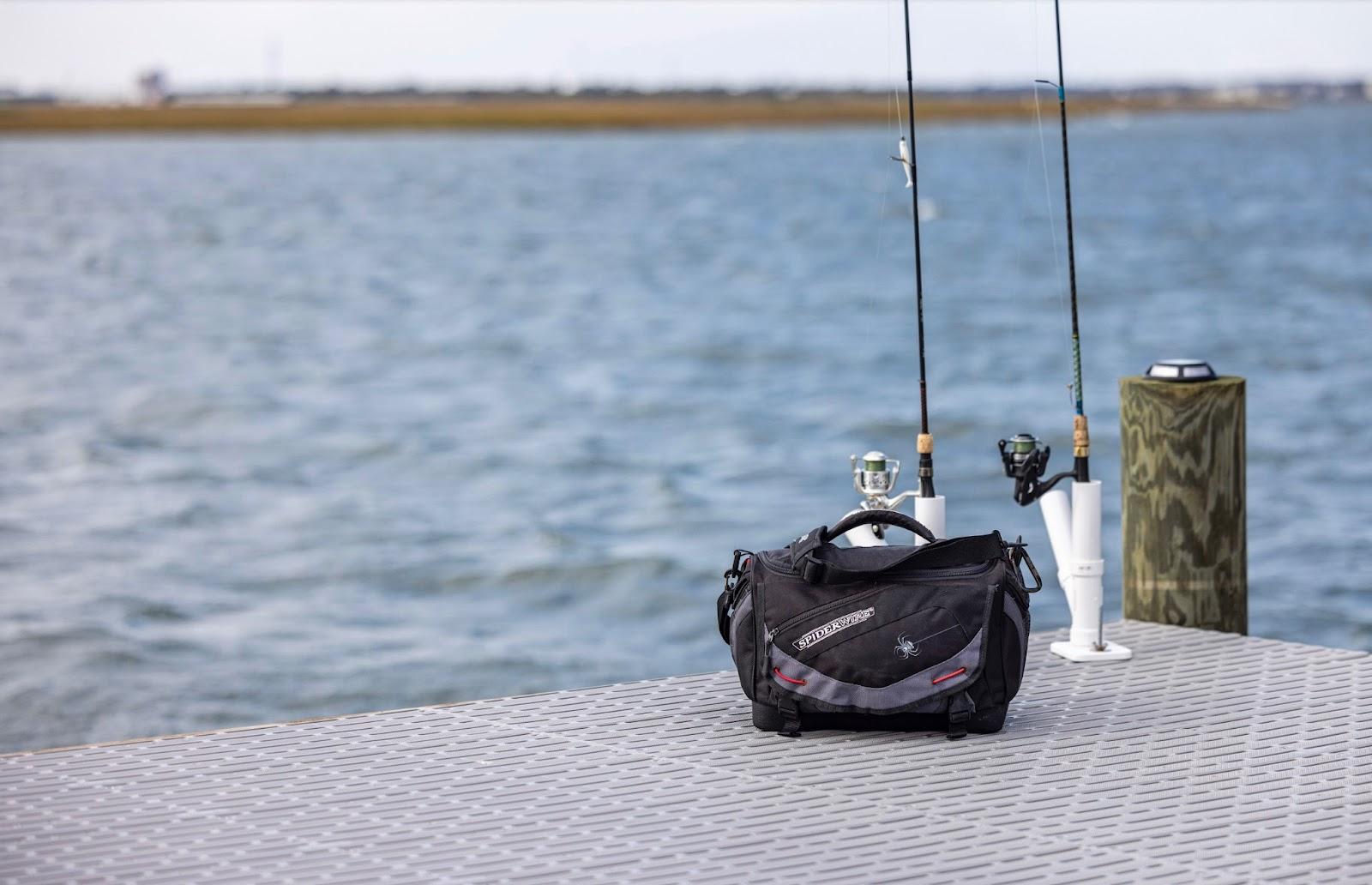 Two fishing poles in their stands sit on the corner of a boat dock. A tackle kit sits next to the rods.