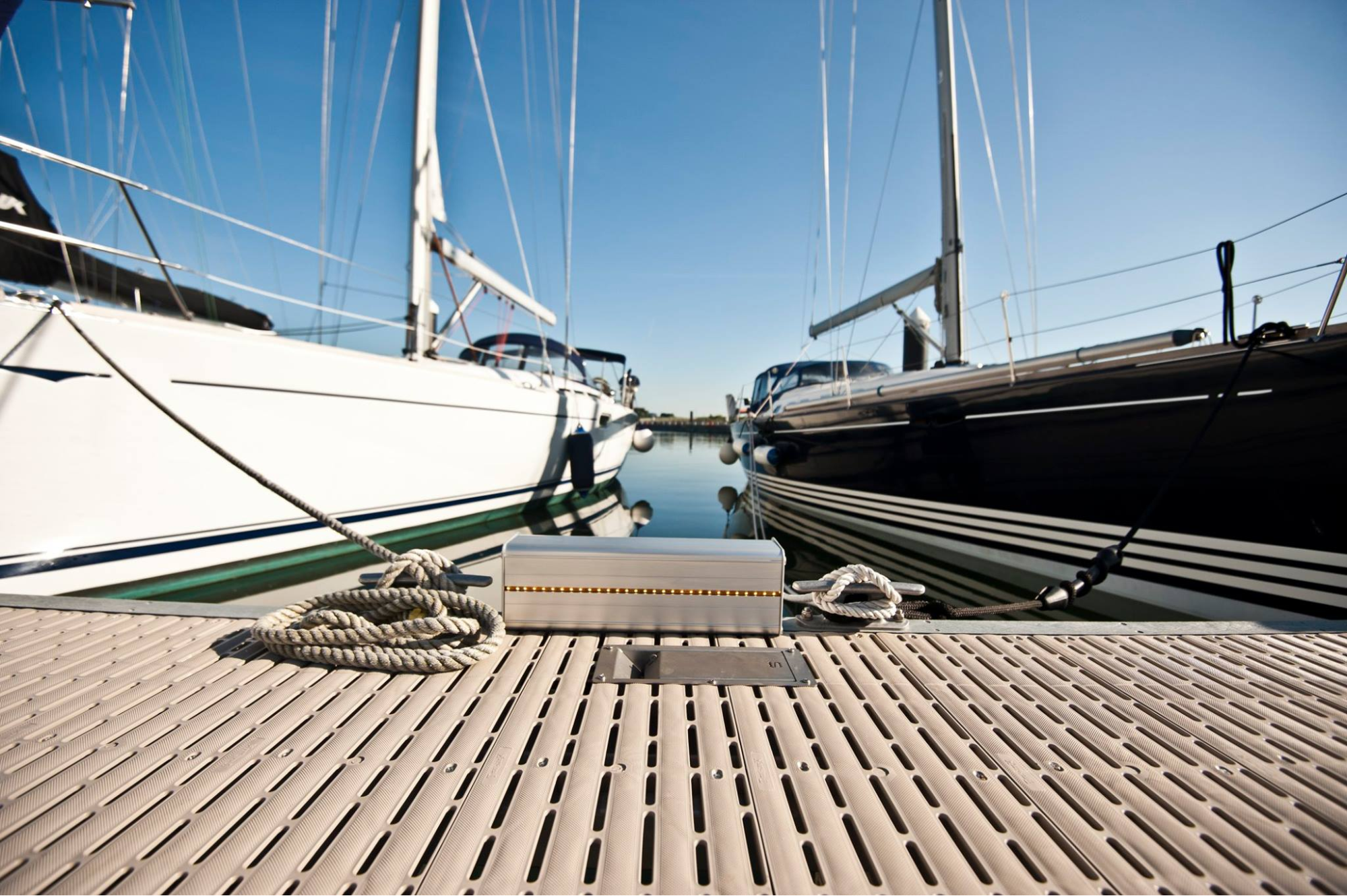 The view of two sailboats from the dock’s level. 